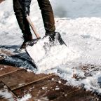 Close up details of working man cleaning out snow from house alley or path using snow shovel