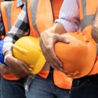 Teamwork of diversity engineer holding helmet standing in row on